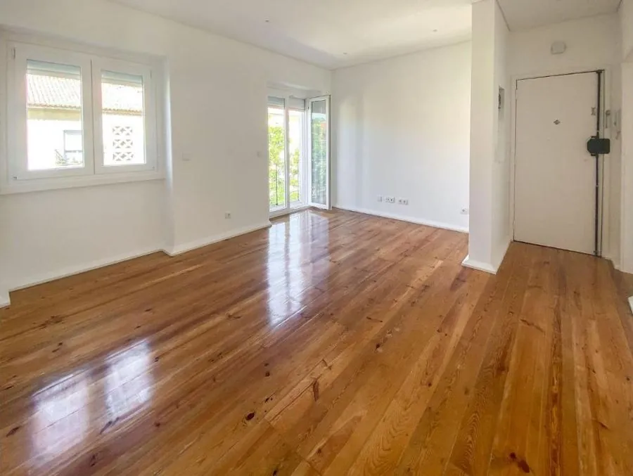 Sala com soalho de pinho e varanda, num apartamento em Lisboa gerido pela Sansa